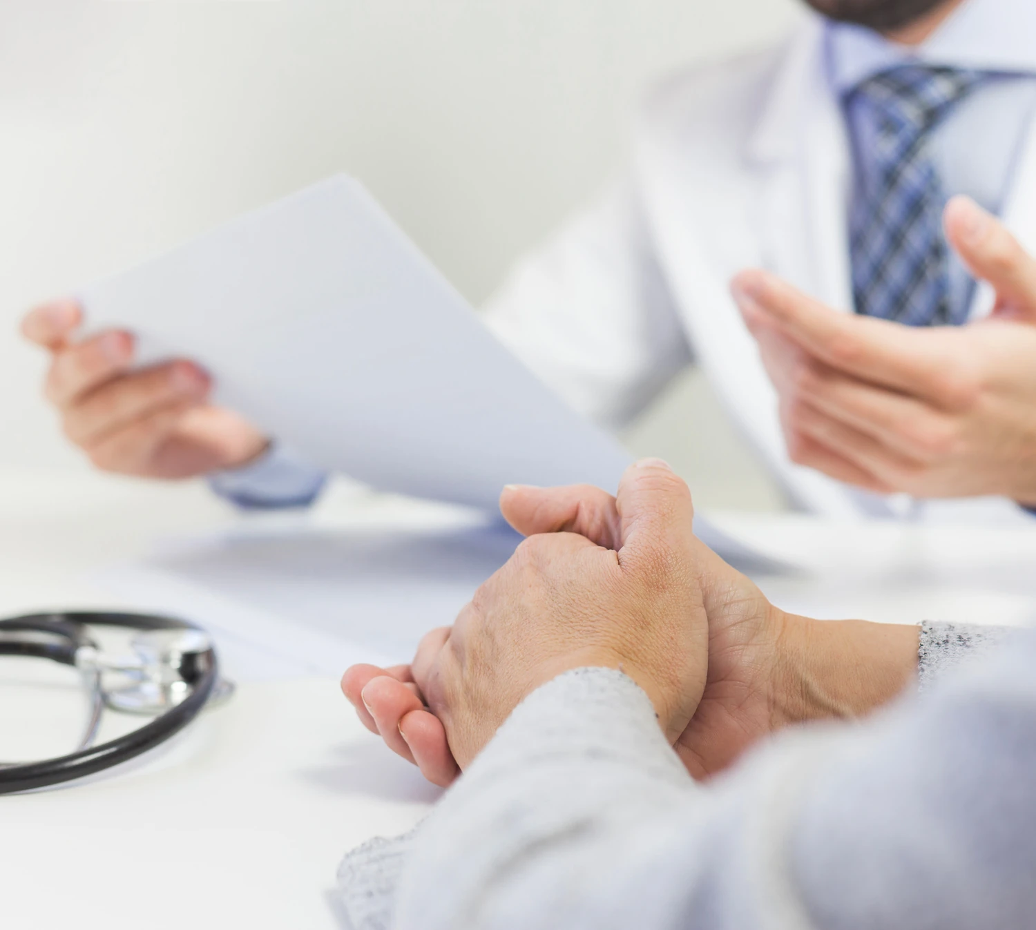 Medico e paziente discutono un documento durante la visita per la mano